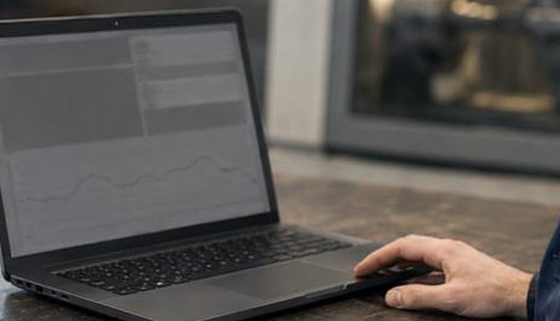 Laptop an einer Werkbank vor einer Werkzeugmaschine